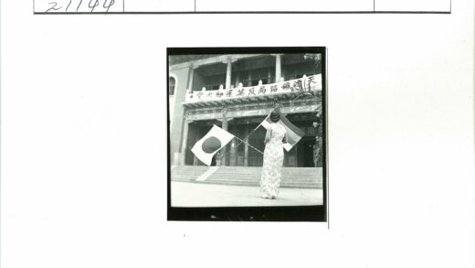 妇女举旗站在建筑前.jpg