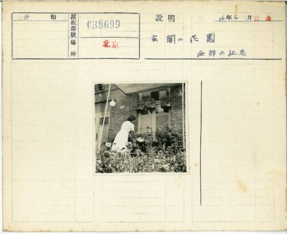 妇女在砖房花园浇水.jpg