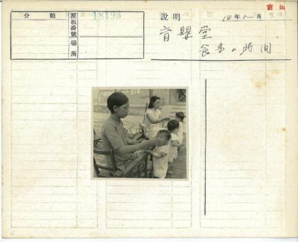 妇女户外喂小孩砖房背景.jpg