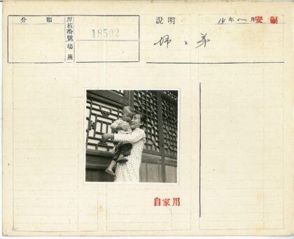 妇女抱婴儿在传统格子窗前.jpg