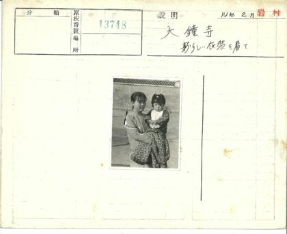 妇女抱小孩砖墙背景.jpg