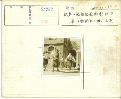 妇女持文件行走砖房旁.jpg