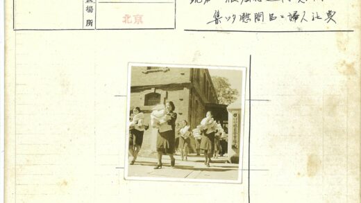 妇女持文件行走砖房旁.jpg