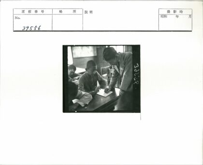 学生在教室课桌写字老师辅导.jpg