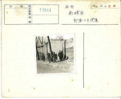 孩子们站在土路旁树墙边.jpg