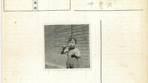 孩子咬棍子站在砖墙前.jpg