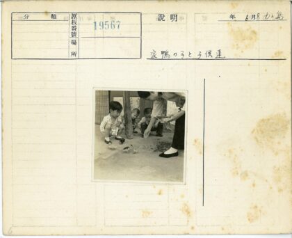 孩童围观妇人喂小鸡.jpg