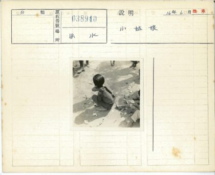 孩童坐人行道旁散落纸张.jpg