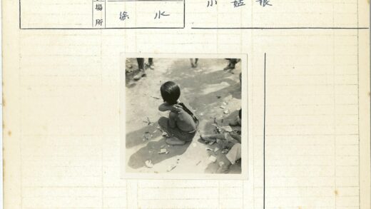 孩童坐人行道旁散落纸张.jpg