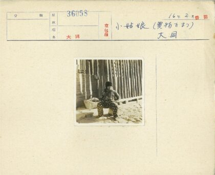孩童坐石篱笆旁.jpg