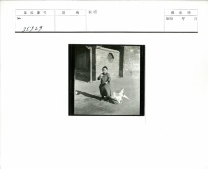孩童持风筝砖墙窗前.jpg