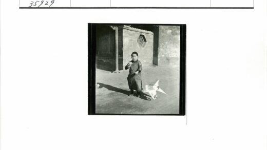 孩童持风筝砖墙窗前.jpg