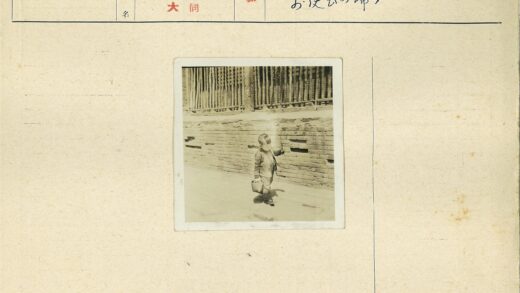 孩童提篮持棍站砖墙旁.jpg