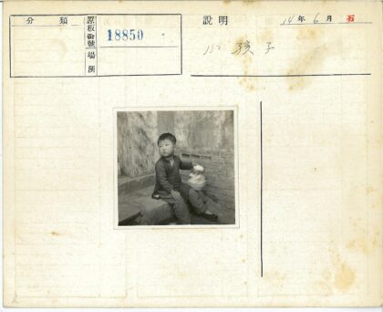 孩童石阶拾趣质朴墙前.jpg