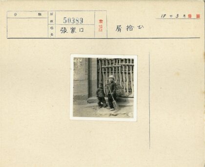 孩童背耙篮站栅栏前.jpg