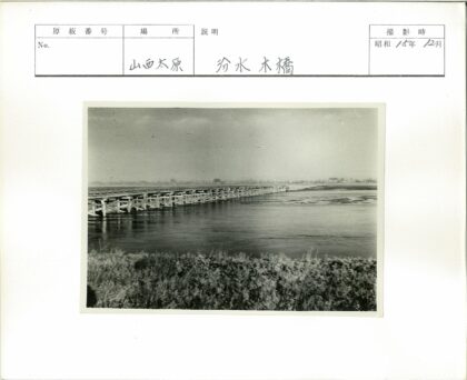 宽阔河流上的长矮木桥黑白照.jpg