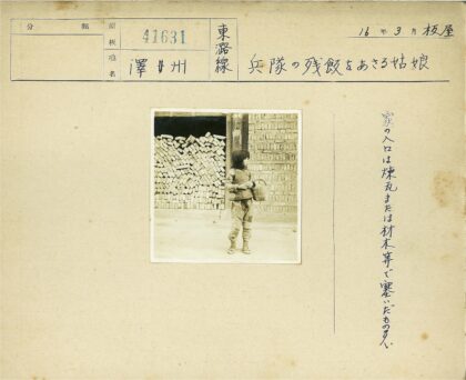 小孩提篮站在砖房前.jpg
