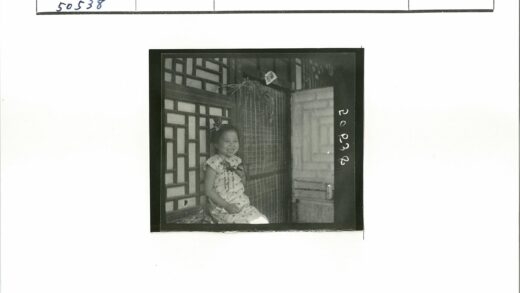 少女微笑坐窗前竹帘花饰.jpg
