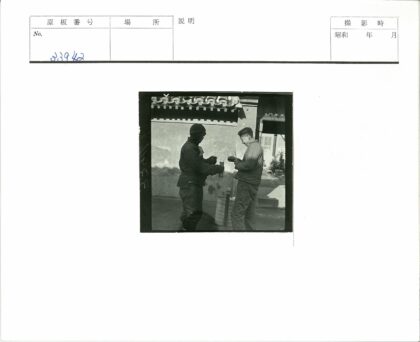 屋顶瓦片石墙建筑旁两人交谈.jpg