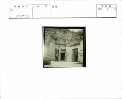 岩石山坡双门洞建筑前人与竹篮.jpg