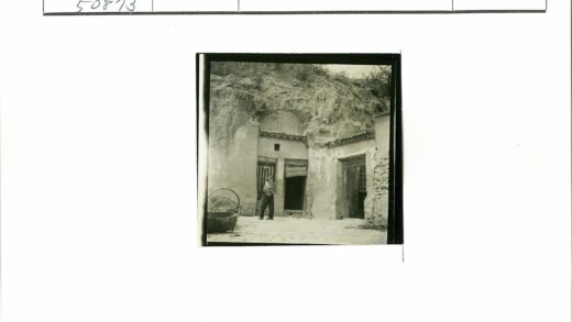 岩石山坡双门洞建筑前人与竹篮.jpg