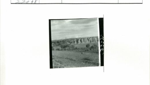 岩石悬崖与田野风景照.jpg