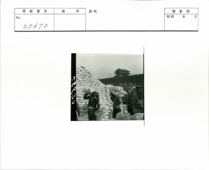 工人扛麻袋古建筑背景.jpg