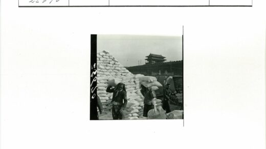 工人扛麻袋古建筑背景.jpg