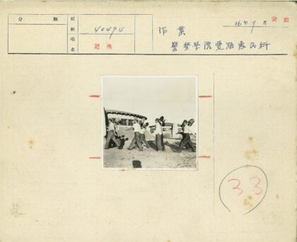 工人持铲在沙地建筑前施工.jpg