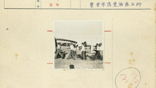 工人持铲在沙地建筑前施工.jpg