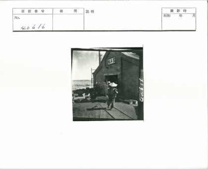 工人提柳条篮砖砌建筑外.jpg
