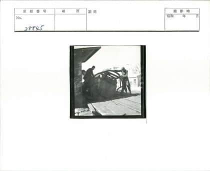工人操作大型机械的木制建筑旁.jpg