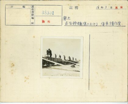 工人用木制坡道装载轨道车货物.jpg