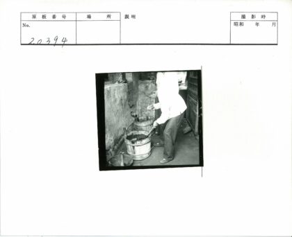 工人舀取木桶液体.jpg