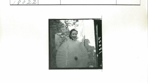 微笑女子持阳伞砖墙背景.jpg