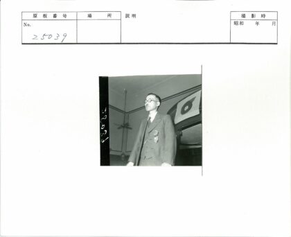 徽章西装男子站国旗前.jpg