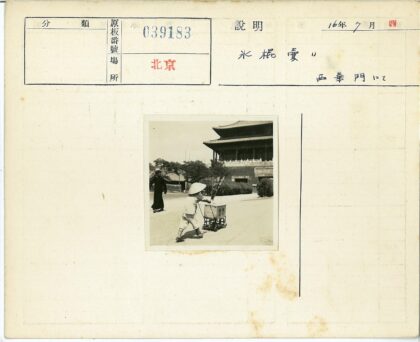 戴圆锥帽推车人行走传统街道.jpg