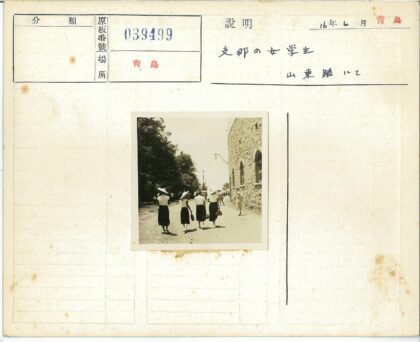 戴宽边帽穿裙子的女人走在石头建筑旁.jpg