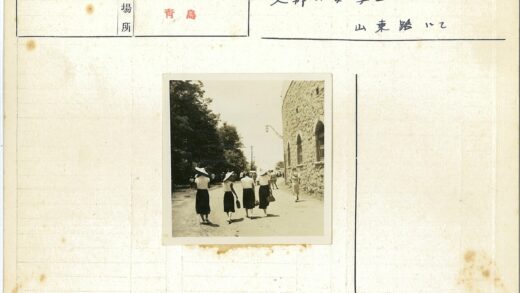 戴宽边帽穿裙子的女人走在石头建筑旁.jpg