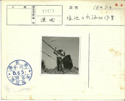 戴帽人持绳站水桶旁晴空下.jpg