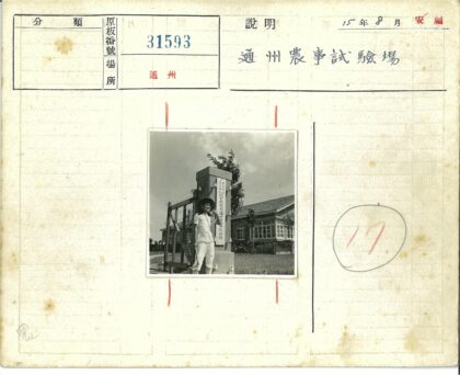 戴帽人站铭文杆旁篱笆建筑.jpg