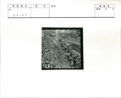 戴帽人群聚集泥泞山路溪边.jpg