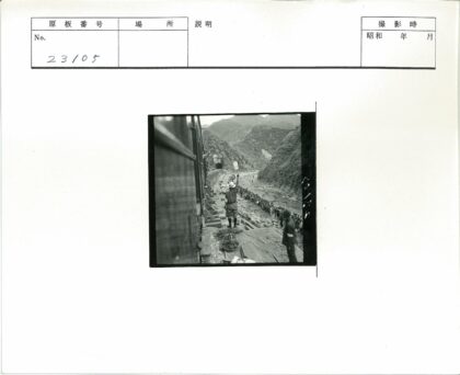 戴帽男子向河边人群挥手火车山脉背景.jpg