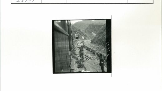 戴帽男子向河边人群挥手火车山脉背景.jpg