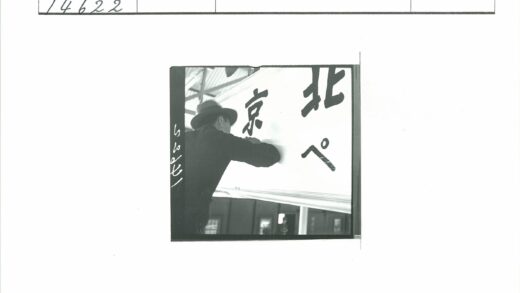戴帽男子日文金属屋顶下举牌.jpg