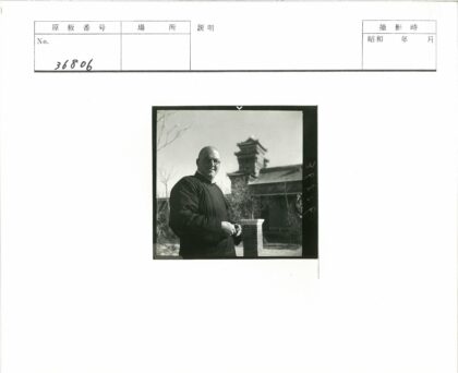 戴眼镜学者站在古塔建筑前.jpg