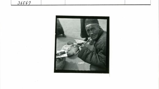 戴黑帽穿大衣男子抽烟斗.jpg