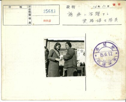 户外砖房前两人手持物品.jpg