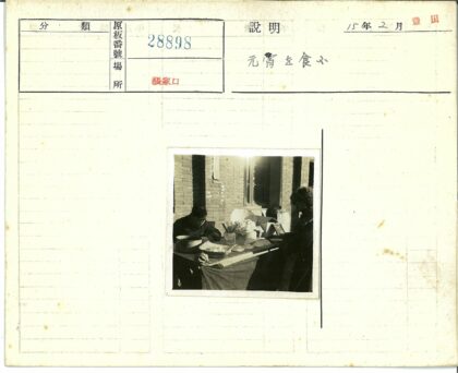 户外餐桌旁两人与砖砌建筑.jpg