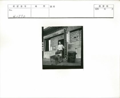 手持木箱的男子与木窗建筑.jpg
